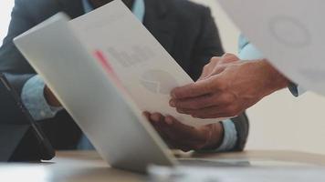 Financial analysts analyze business financial reports on a digital tablet planning investment project during a discussion at a meeting of corporate showing the results of their successful teamwork. video