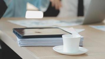 Financial analysts analyze business financial reports on a digital tablet planning investment project during a discussion at a meeting of corporate showing the results of their successful teamwork. video