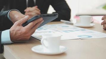 Financial analysts analyze business financial reports on a digital tablet planning investment project during a discussion at a meeting of corporate showing the results of their successful teamwork. video