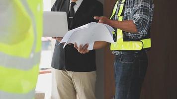 arquitecto hombre trabajando con ordenador portátil y planos, ingeniero inspección en lugar de trabajo para arquitectónico plan, bosquejo un construcción proyecto ,selectivo foco,negocio concepto Clásico color video