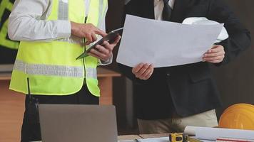 architect Mens werken met laptop en blauwdrukken, ingenieur inspectie in werkplaats voor bouwkundig plannen, schetsen een bouw project ,selectief focus, zaken concept wijnoogst kleur video