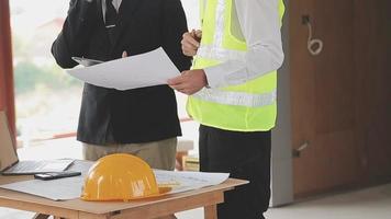 arquitecto hombre trabajando con ordenador portátil y planos, ingeniero inspección en lugar de trabajo para arquitectónico plan, bosquejo un construcción proyecto ,selectivo foco,negocio concepto Clásico color video