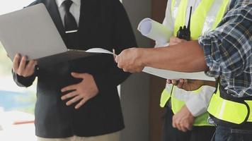 arquitecto hombre trabajando con ordenador portátil y planos, ingeniero inspección en lugar de trabajo para arquitectónico plan, bosquejo un construcción proyecto ,selectivo foco,negocio concepto Clásico color video