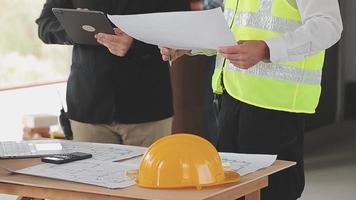 arquitecto hombre trabajando con ordenador portátil y planos, ingeniero inspección en lugar de trabajo para arquitectónico plan, bosquejo un construcción proyecto ,selectivo foco,negocio concepto Clásico color video