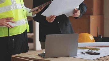 architect Mens werken met laptop en blauwdrukken, ingenieur inspectie in werkplaats voor bouwkundig plannen, schetsen een bouw project ,selectief focus, zaken concept wijnoogst kleur video