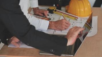 architect man working with laptop and blueprints,engineer inspection in workplace for architectural plan,sketching a construction project ,selective focus,Business concept vintage color video