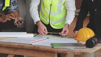 arquitecto hombre trabajando con ordenador portátil y planos, ingeniero inspección en lugar de trabajo para arquitectónico plan, bosquejo un construcción proyecto ,selectivo foco,negocio concepto Clásico color video