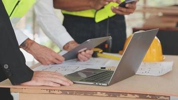 arquitecto hombre trabajando con ordenador portátil y planos, ingeniero inspección en lugar de trabajo para arquitectónico plan, bosquejo un construcción proyecto ,selectivo foco,negocio concepto Clásico color video