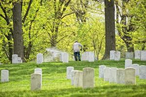 man cleaning arlington cemetery graveyard photo