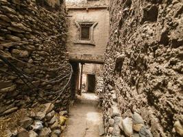 The narrow lanes passing through mud stone walls and tunneled passages through old houses in the ancient village of Kagbeni on the Annapurna Circuit trail in the region of Mustang in Nepal. photo