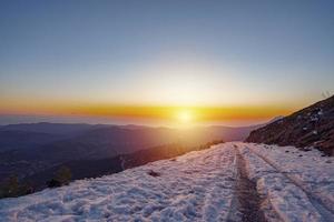 scenic view of empty road with snow covered landscape in winter season photo