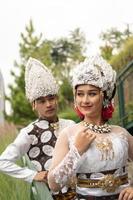 a couple in white clothes posing very intimately and intimately in a park photo