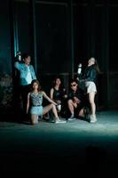 a group of teenagers in quirky clothes posing together as friends in a disco bar with a very cool expression photo