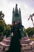 a pair of Asian teenagers standing in front of the funeral monument and facing each other with all black clothes and scary expressions photo