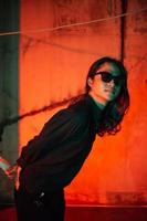 a man with long hair wearing a black shirt and clothes posing very sexy in an old factory photo