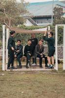 a group of Asian teenagers in black clothes stylized as naughty children while gathering at a cafe photo