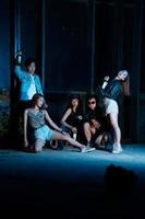 a group of teenagers in quirky clothes posing together as friends in a disco bar with a very cool expression photo