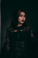 un de miedo asiático mujer con negro labios participación su todo negro ropa cuando visitando el cementerio foto