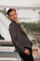 a grown man in a gray suit posing around a cafe table in a very manly and masculine manner before entering the office photo