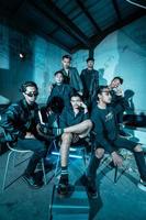 a group of Asian teenagers in black clothes posing very coolly while sitting in a warehouse chair which is lit blue photo