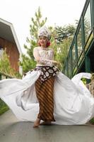 a bride in a white dress is standing in the middle of the bridge with her face full of makeup and a white cloth floating in the air photo