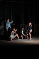 a group of teenagers in quirky clothes are enjoying a party together at the end of the year in an old building photo