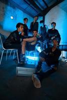 un grupo de asiático adolescentes en negro ropa reunido a un sede cuando reunión con su amigos foto