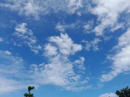 Beautiful white clouds on deep blue sky background. Large bright soft fluffy clouds are cover the entire blue sky. photo