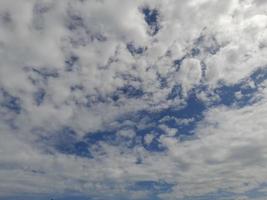 Beautiful white clouds on deep blue sky background. Large bright soft fluffy clouds are cover the entire blue sky. photo