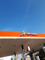 Mataram City, Lombok Island, Indonesia. February 22, 2023. The Pertamina logo is seen at a Pertamina gas station in downtown Mataram City on the Lombok Island. photo