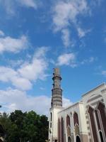 Mosque minaret against blue sky background photo