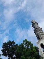Mosque minaret against blue sky background photo