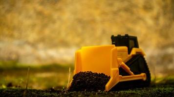 South Minahasa, Indonesia January 2023, a yellow bulldozer toy is leveling the ground photo