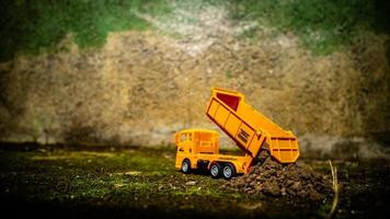 South Minahasa, Indonesia  January 2023, a yellow dump truck toy transporting sand photo