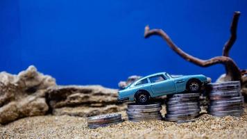 minahasa, Indonesia  January 2023, toy car on a pile of coins, saving for the future, managing successful transportation business technology concept photo