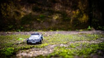 South Minahasa, Indonesia  January 2023, a toy car on a mossy floor that looks like grass photo