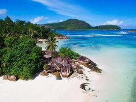 Drone shot of rock boulders near the ocean with palm trees on Mahe island, Seychelles photo