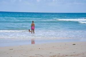 Mahe Seychelles 02.02.2023  clients on the beach watching watching her child and the waves photo