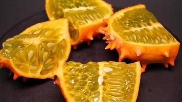 Ripe kiwano on a black background twirl video