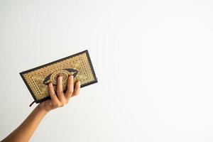 Hand holding Quran book isolated for copy space photo