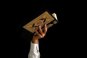 hombre mano participación un Corán libro foto