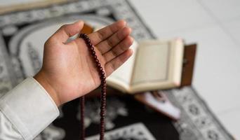 hand holding a rosary and praying photo