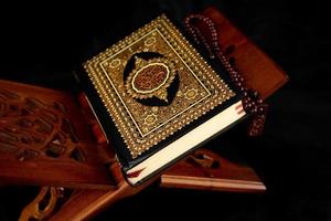 Quran book with a rosary on the table photo