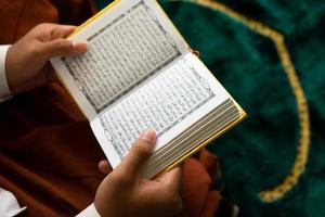 man reading a Quran book photo