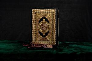 Stand Quran book isolated on black background photo