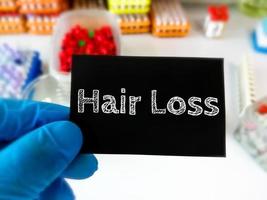 Hair Loss conceptual image with laboratory background, hair treatment concept. photo