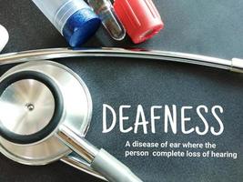 Deafness term with medical equipment's on black background, medical conceptual image. photo