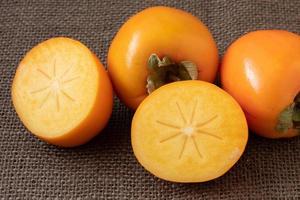 Whole and half of fresh ripe persimmons. Japanese persimmon photo