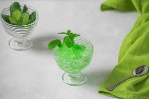 Summer Sicilian dessert granita, frozen juice of fresh cucumber and mint on a white background. Summer cooling, tonic cocktail of crushed ice, a kind of sherbet. photo