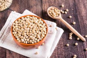 Ripe soybeans in a bowl and spoon on the table. Vegetable protein and antioxidant. photo
